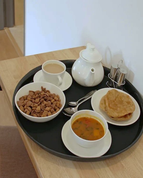 A room-service tray with tea, poori and sabzi